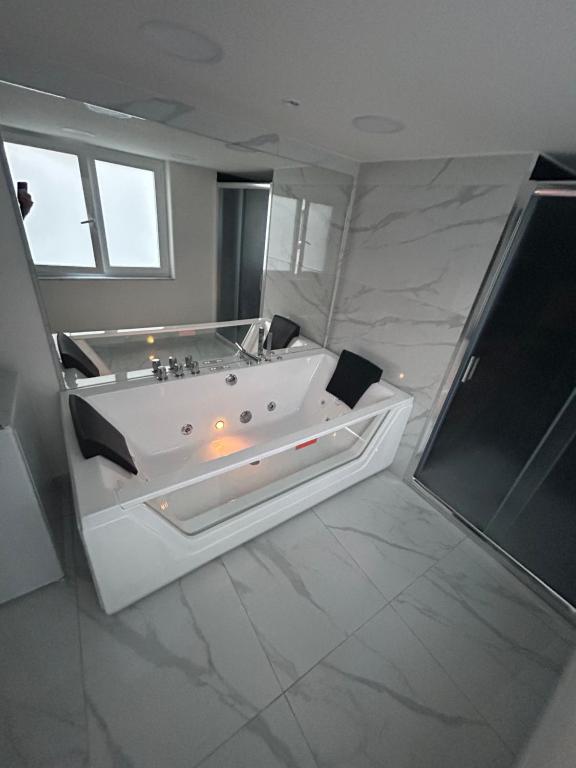 a large white bathroom with a tub and a window at LUIGI LUXURY SUITE in Naples