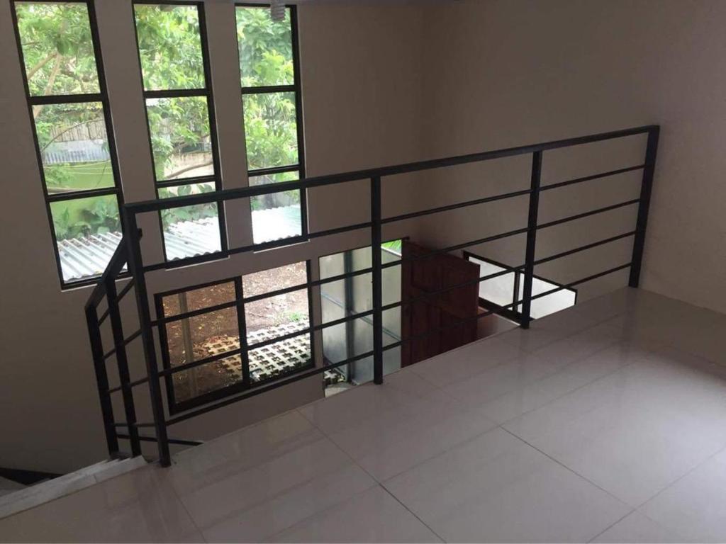 an empty room with a spiral staircase with windows at Apartamento La Guaria in Turrialba