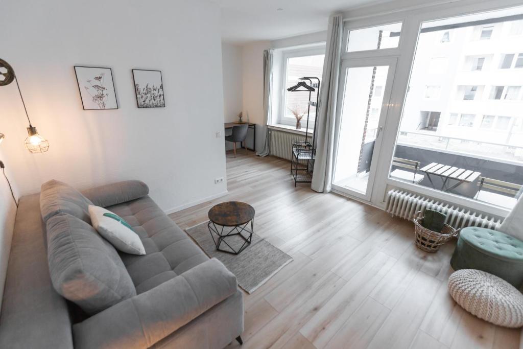 - un salon avec un canapé et une grande fenêtre dans l'établissement Koje Sechs I Apartment im Zentrum mit Hafenblick, à Bremerhaven