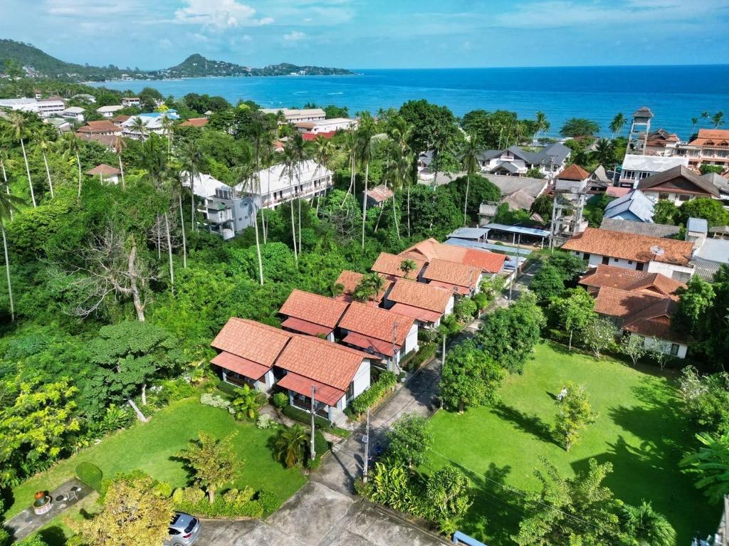 an aerial view of a village with houses and the ocean at Bluewhale Home Samui in Amphoe Koksamui