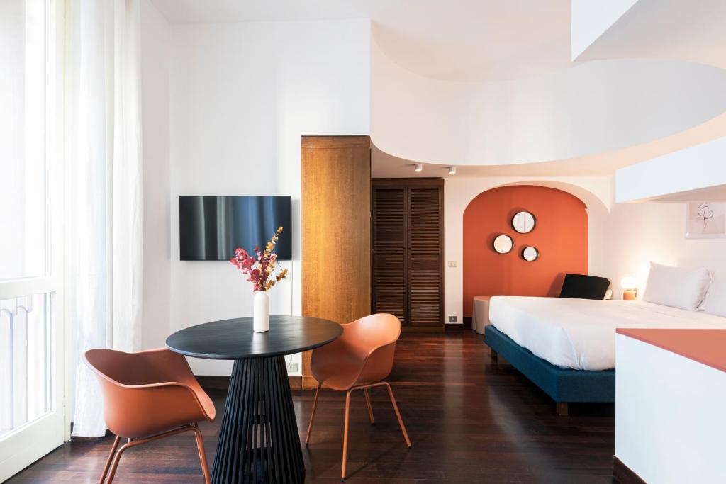 pokój hotelowy z łóżkiem, stołem i krzesłami w obiekcie RELSTAY - Montenapoleone Suite w Mediolanie