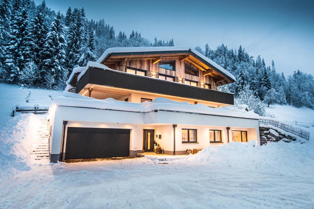a house in the snow with a lot of snow at FOUR PEAKS Apartment in Flachau