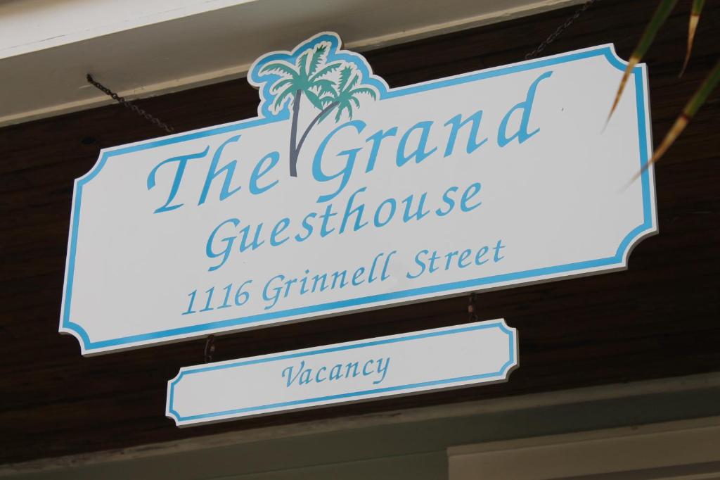 a sign for the grandose guesthouse with a palm tree at The Grand Guesthouse in Key West