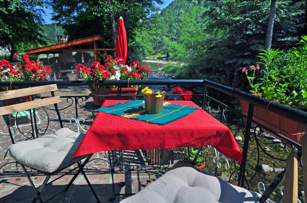 un patio con mesa y mantel rojo en House By The River, en Teteven