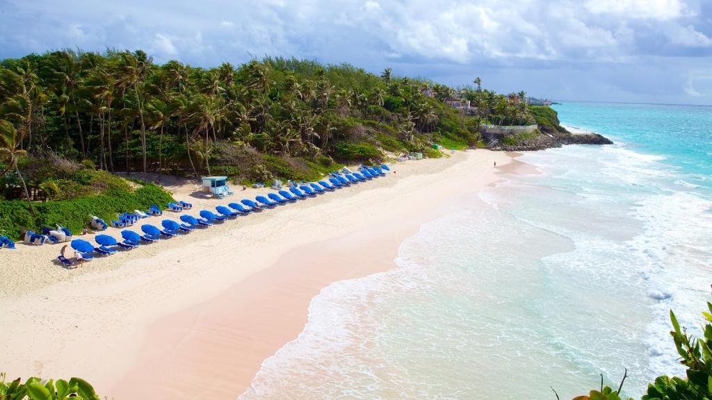 an empty beach with blue chairs and the ocean at Cozy Modern Upstairs 2 Bed A/C Apt Near 2 Everything in Saint Philip