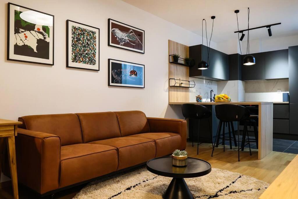 salon z brązową kanapą i kuchnią w obiekcie Luxury Infusion by HOME Apartments - Free Parking w Zagrzebiu