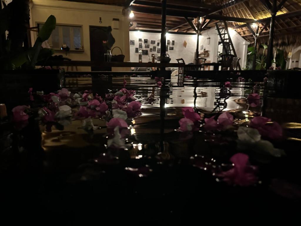 Une bande de fleurs roses assises sur une table dans l'établissement My Secret Home, à Seminyak