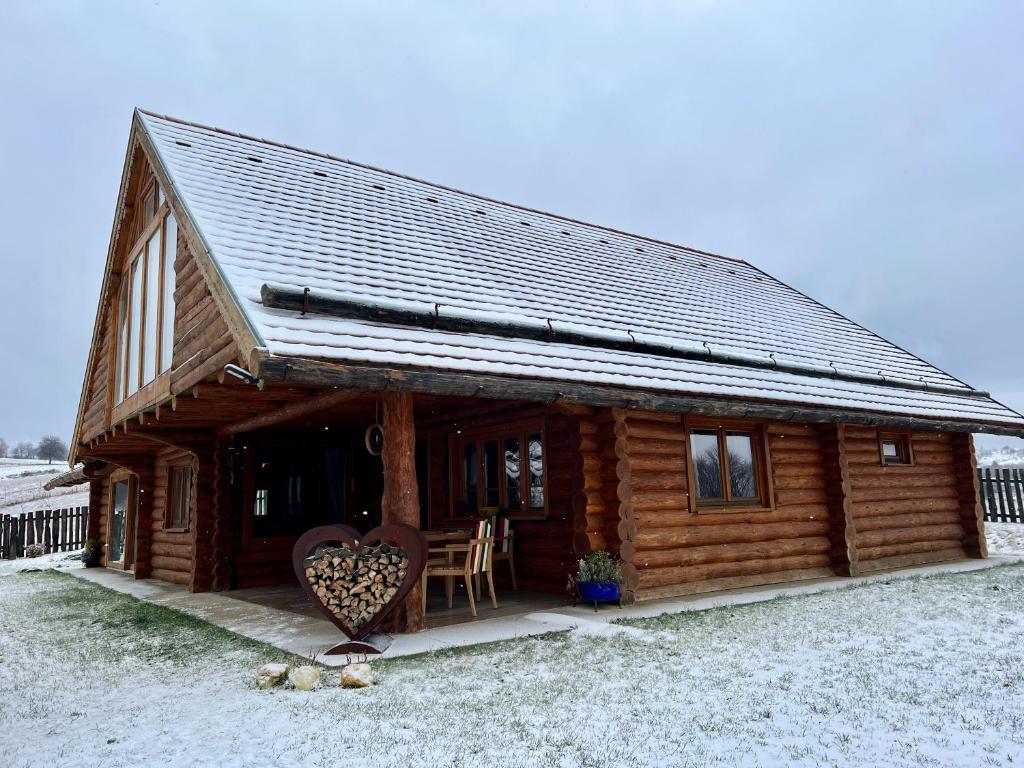 a log cabin with a heart in front of it at Cabana Huta Slavia in Şinteu