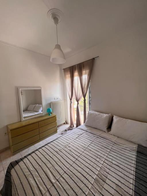 um quarto com uma cama grande e uma janela em Elena’s apartment em Áyios Vasílios