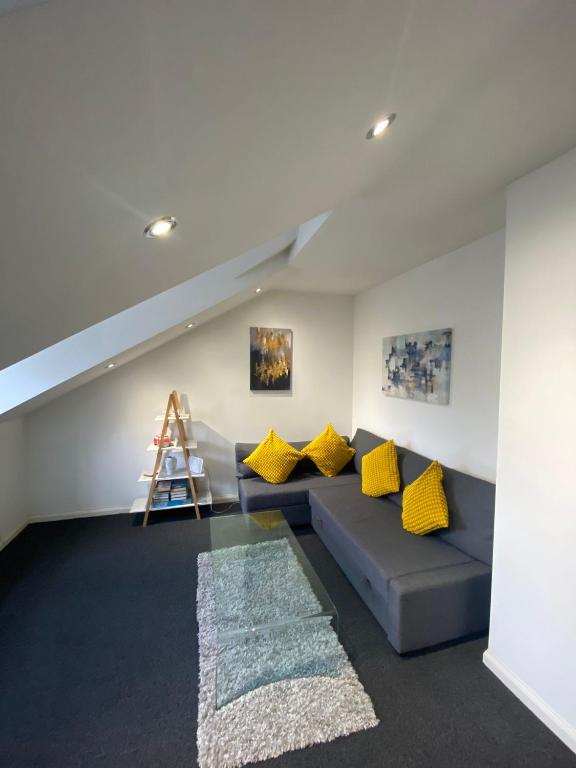 - un salon avec un canapé bleu et des oreillers jaunes dans l'établissement Impeccable 1-Bed Apartment in Putney Village, à Londres