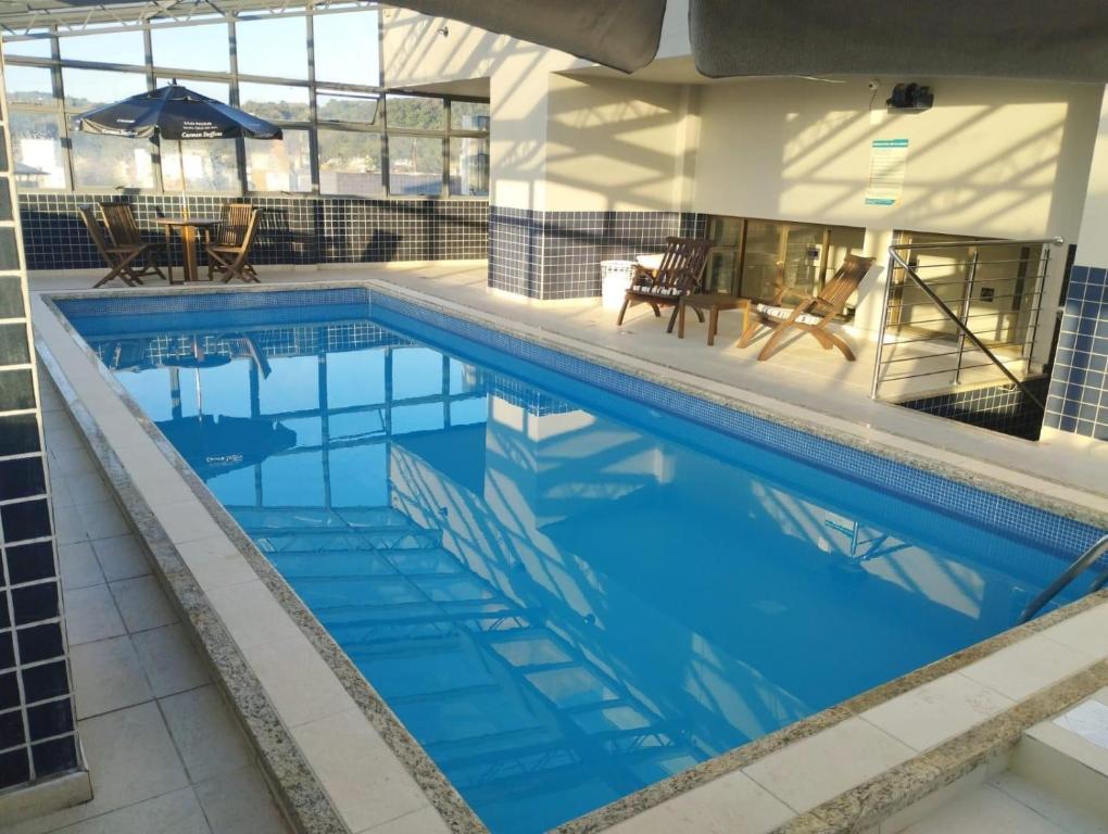 a swimming pool with blue water in a building at Aquarius Flat Studio 509 in Santa Cruz do Sul