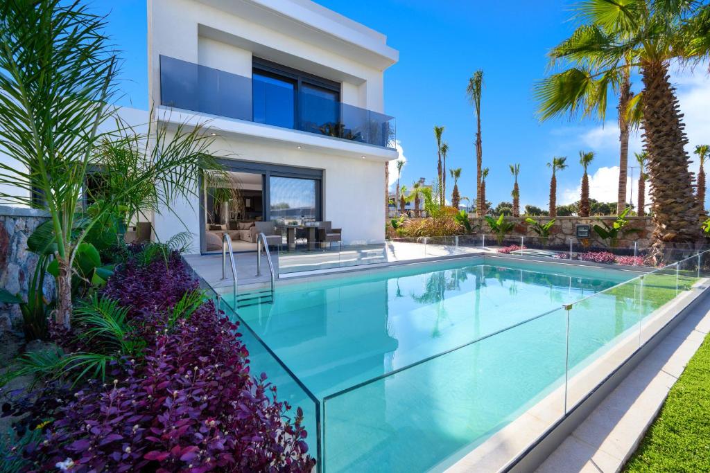 克雷馬斯蒂的住宿－Penélope Beachfront Villa，一座别墅,设有游泳池和棕榈树