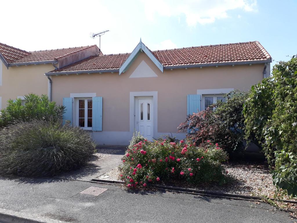 a white house with blue windows and flowers at Villa Vanille in Châtelaillon-Plage