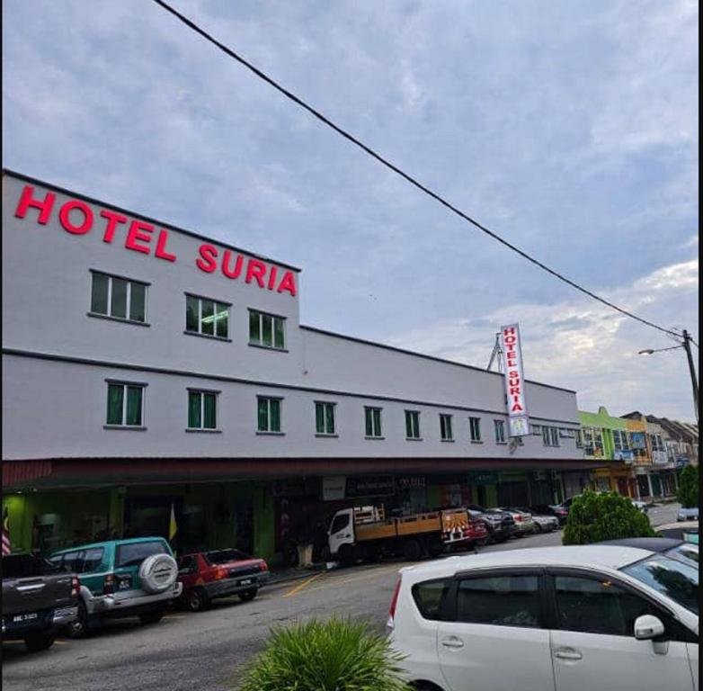 JQ Suria Hotel في Lahat: فندق سونينا مع سيارات متوقفة في موقف للسيارات