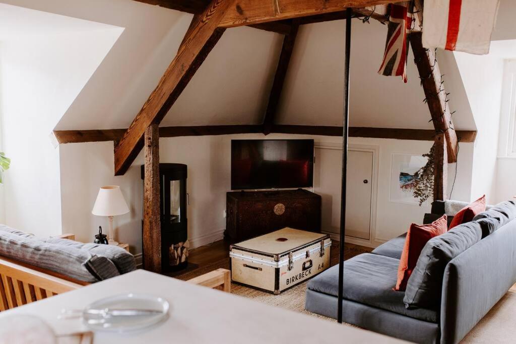 a living room with a couch and a tv at The Loft in Sherborne: central with parking in Sherborne