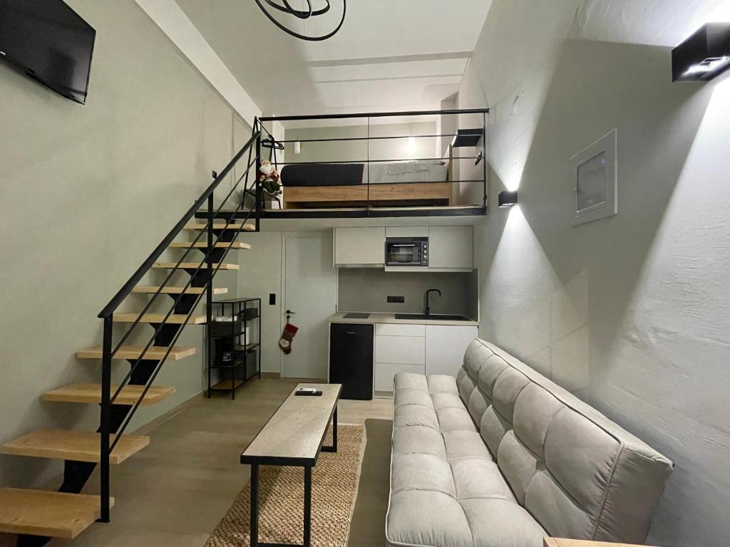 a living room with a couch and a spiral staircase at Nikitas loft in Kalamata