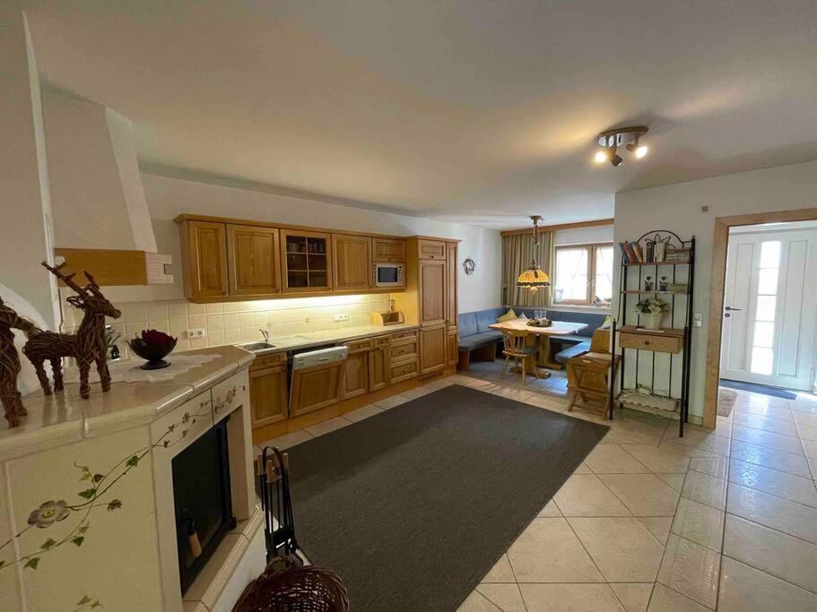 a kitchen with wooden cabinets and a living room at Haus Peppone in Mathon