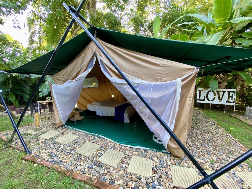 ein Zelt mit einem Bett und einem Schild, auf dem Liebe steht in der Unterkunft Hostel Glamping Mistiko Safari - Carmen de apicala in Carmen de Apicalá