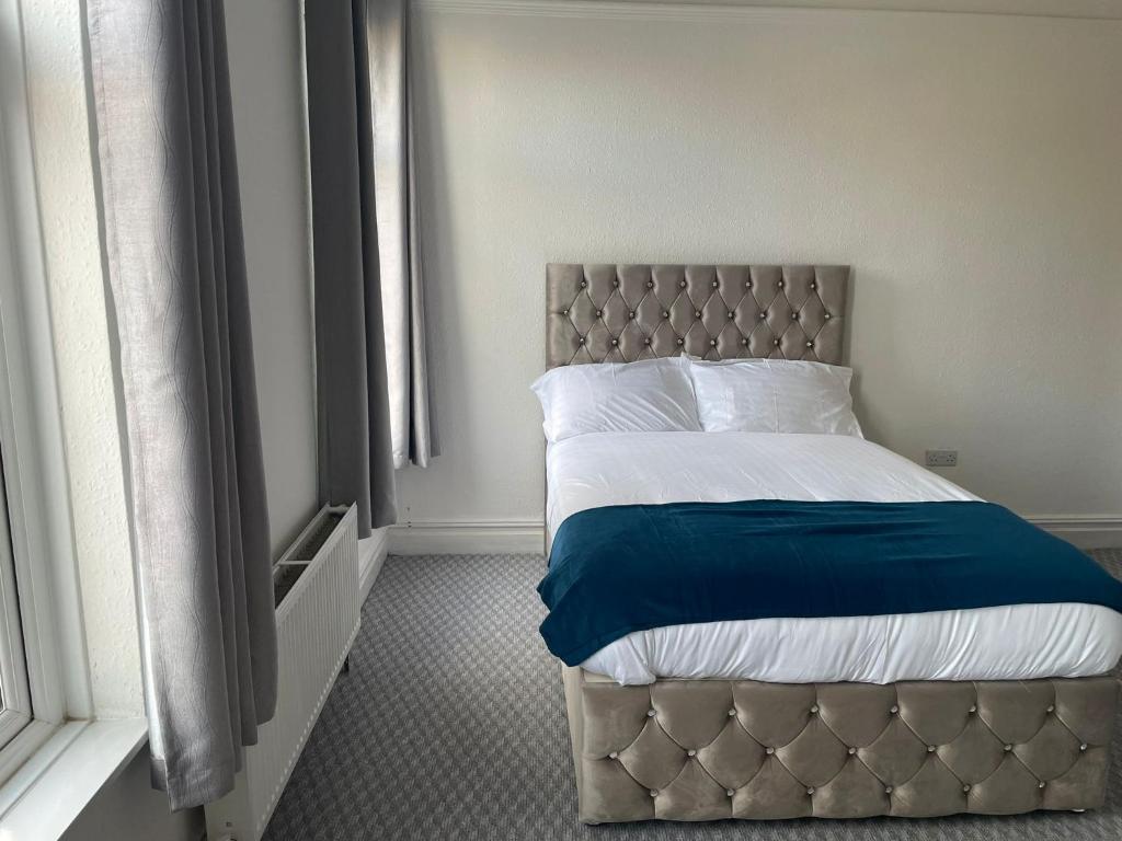 a bedroom with a large bed with blue and white sheets at Cosy Studio in Manchester