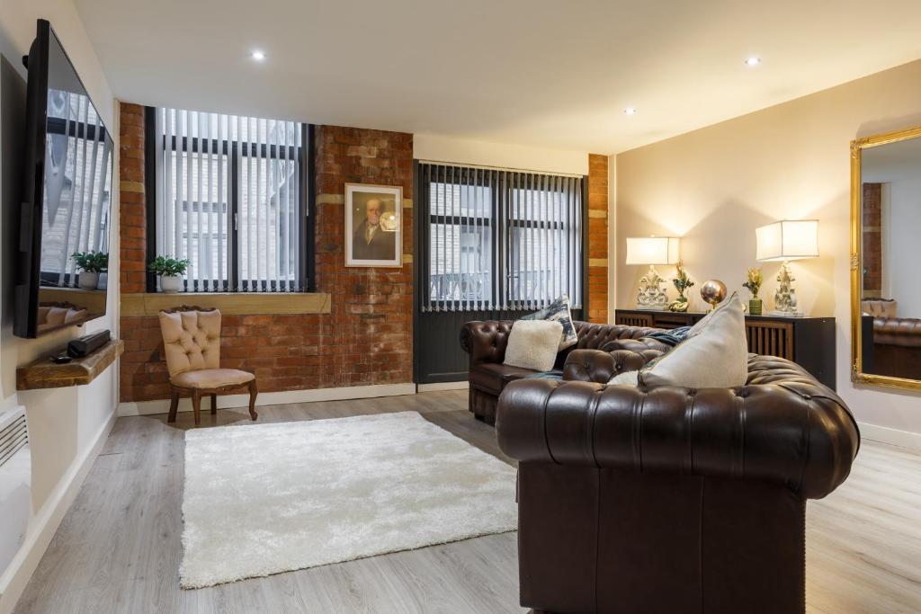 uma sala de estar com um sofá de couro e cadeiras em Outside Balcony Lux Apartment em Bradford