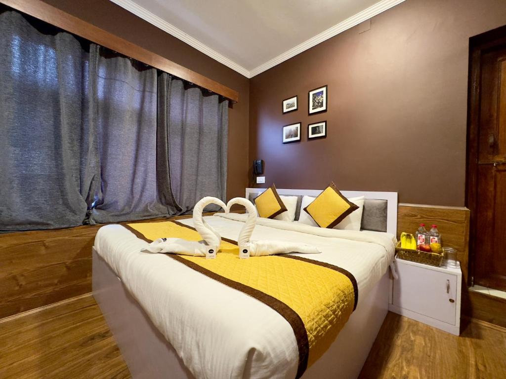 een slaapkamer met een groot bed met gele en witte lakens bij Hotel Jafson Accommodates in Srinagar