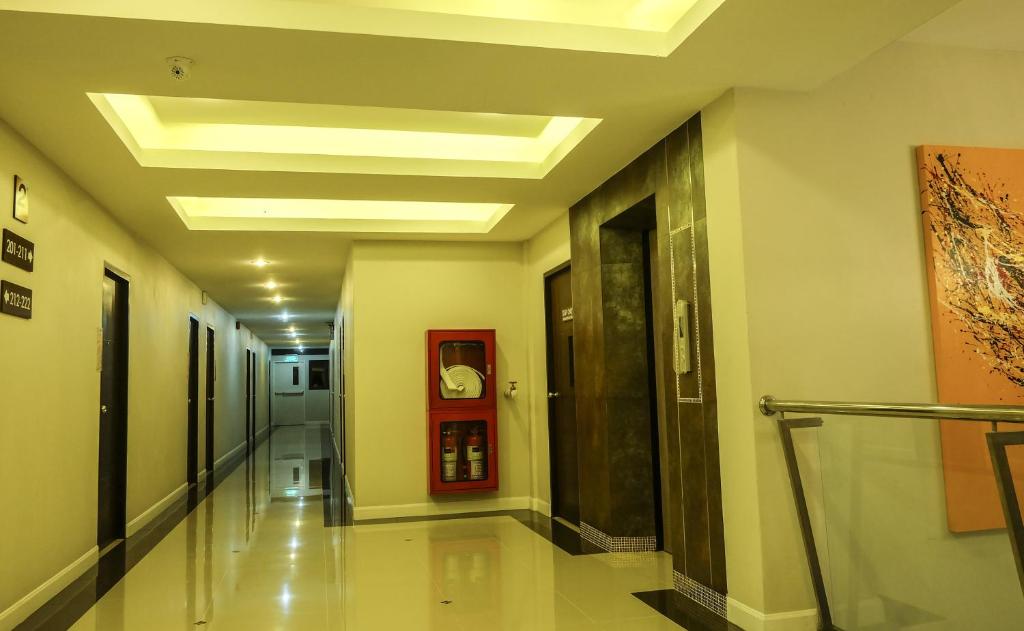 A long hotel corridor beside the elevators and a glass stair railing.