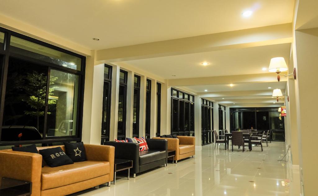 A lounge and seating area extending toward tables beside tall windows.