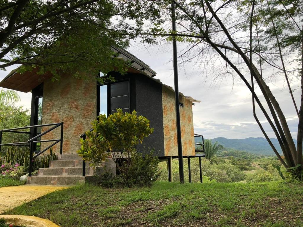 ein Haus auf einem Hügel mit Treppen und Bäumen in der Unterkunft Suite Pacandé , cerca al desierto de la tatacoa in Aipe