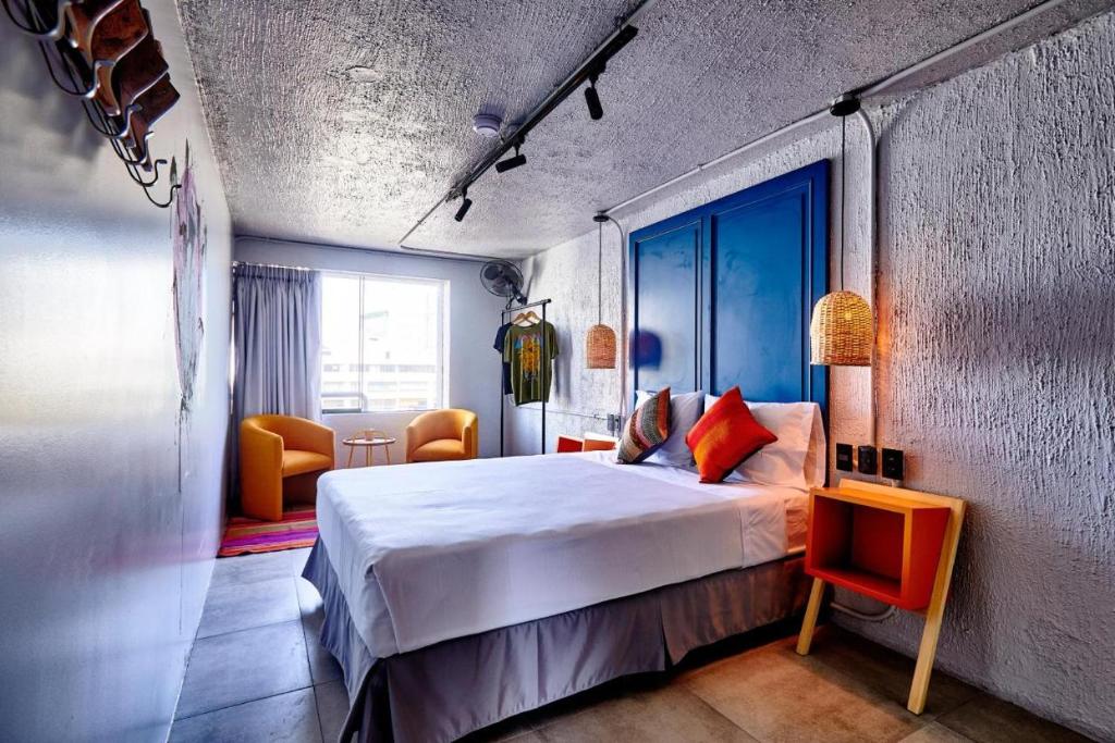 1 dormitorio con 1 cama grande y sillas en HOTEL VIP 46 SSQS, en Bagua Grande