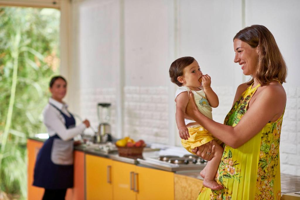 a woman holding a little girl in a kitchen at Calaserena Resort in Geremèas
