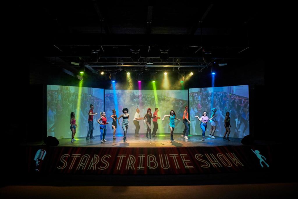 a group of people dancing on a stage at Calaserena Resort in Geremèas