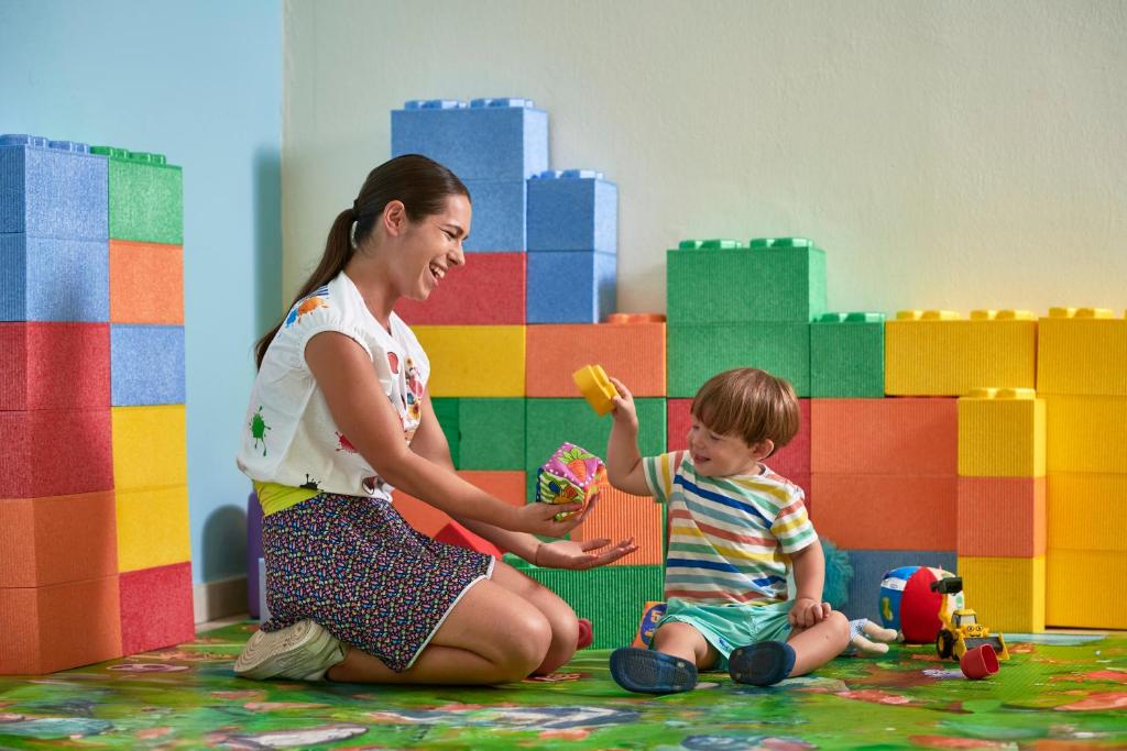 a woman and a child playing with a toy at Calaserena Resort in Geremèas