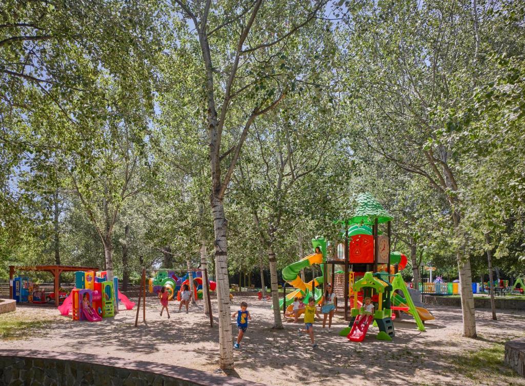 a playground in a park with children playing in it at Calaserena Resort in Geremèas