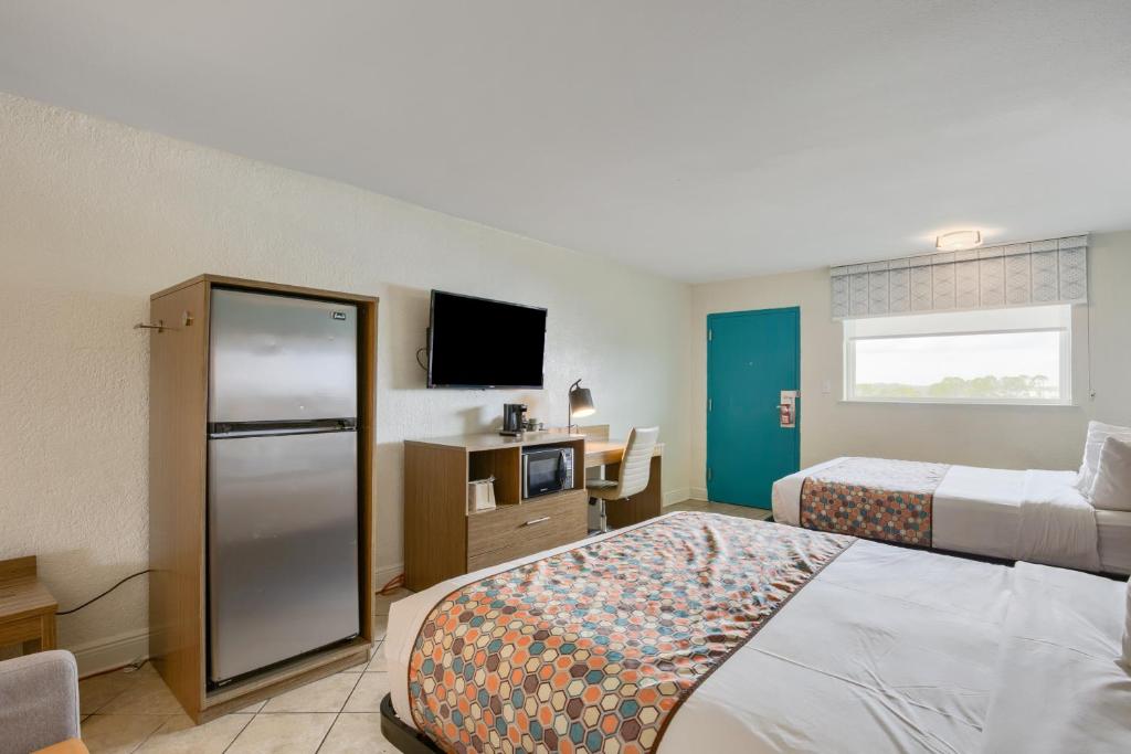 a hotel room with two beds and a television at Beachside Resort Hotel in Gulf Shores