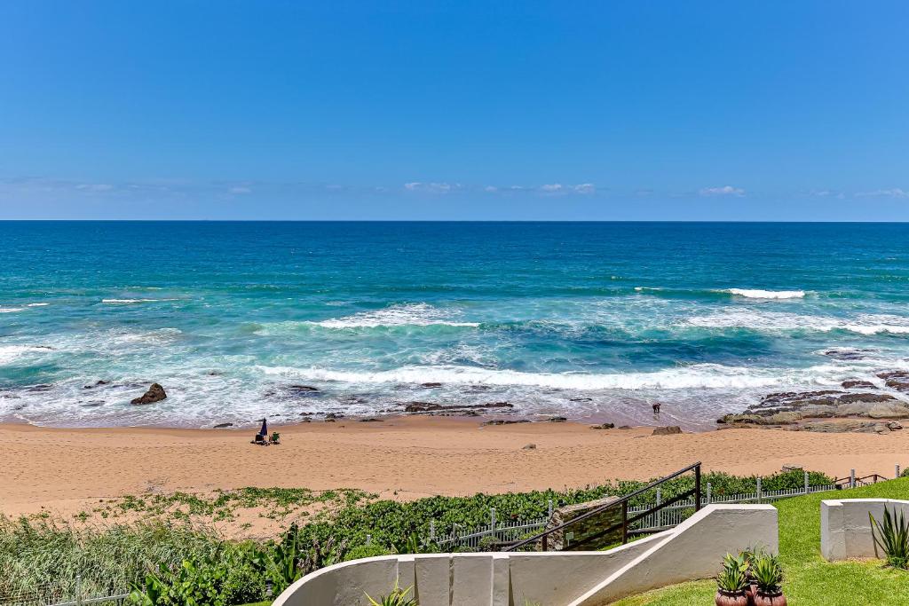 a beach with a staircase leading to the ocean at Chakas Terrace 7 - Luxurious Beach House in Ballito