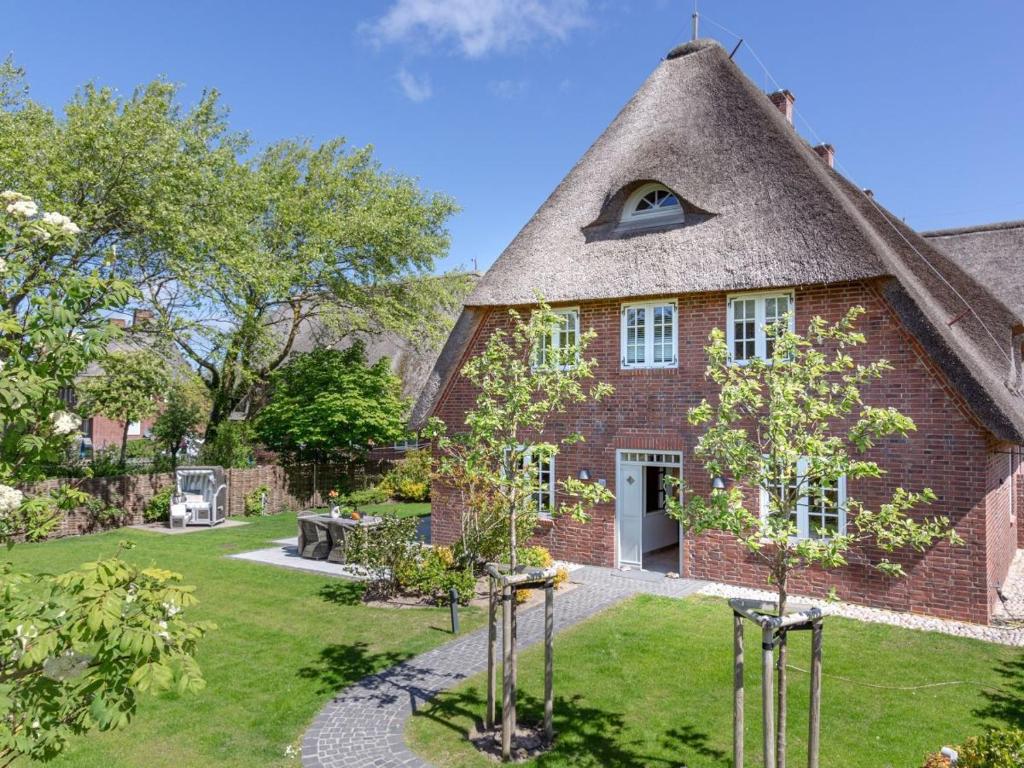 una vecchia casa in mattoni con tetto di paglia di Ferienhaus Silbermöwe 7d a List