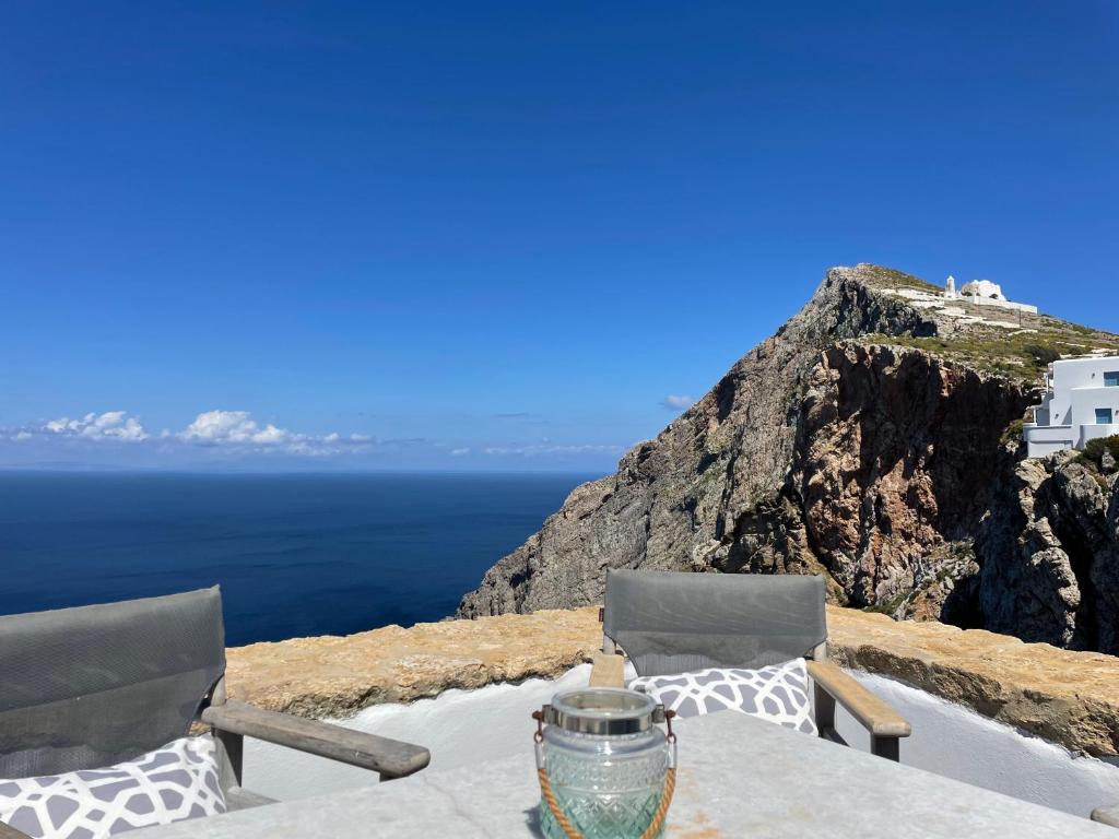 una mesa y sillas con vistas al océano en Folegandros-Cliffhouse, en Chora Folegandros