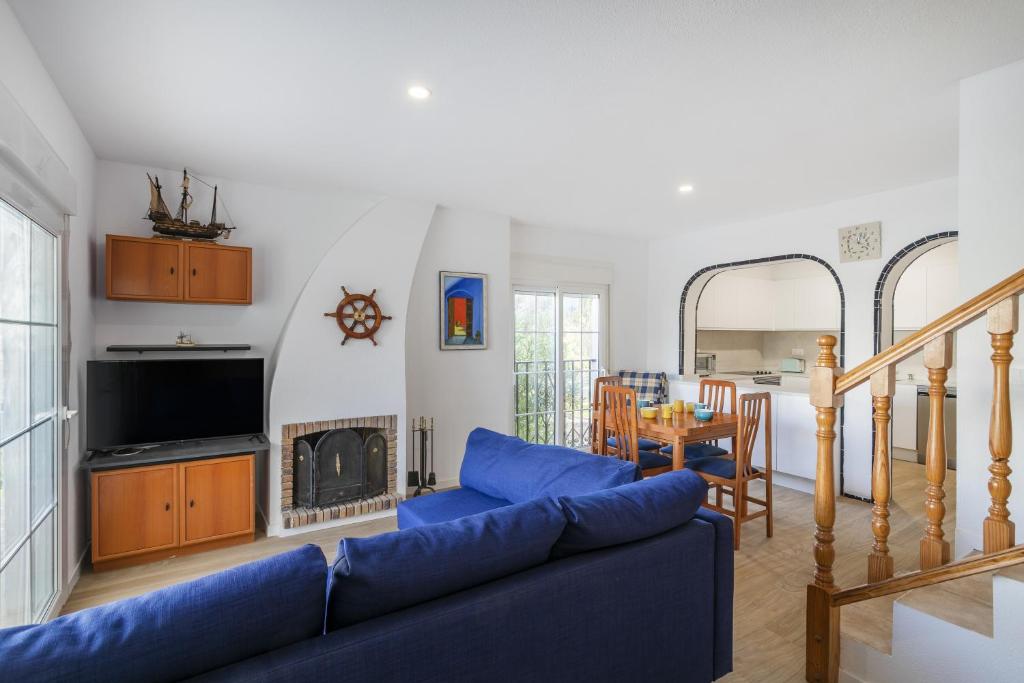 Una sala de estar con un sofá azul y una chimenea. en Bungalow 213, en Puerto Marino