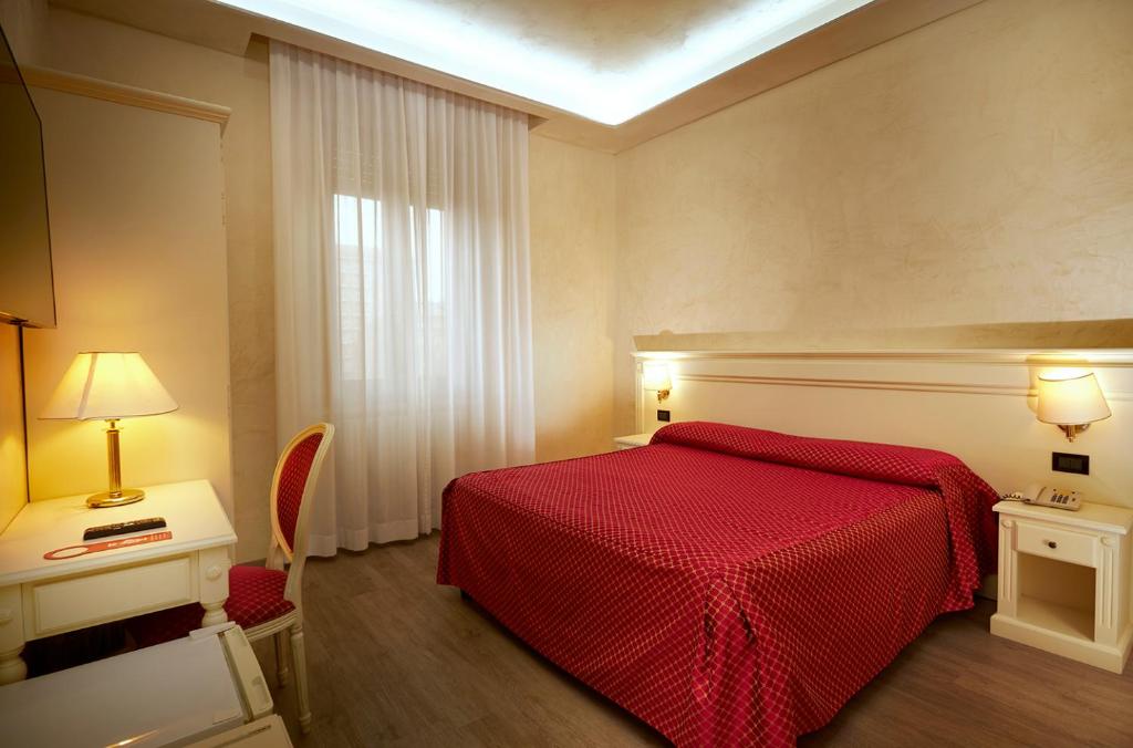 a bedroom with a red bed with a red blanket at Hotel Galimberti in Turin