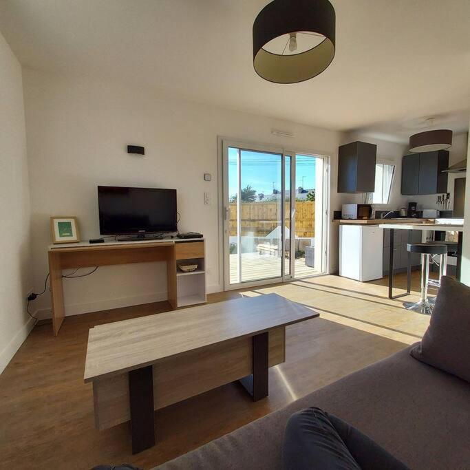 un salon avec une table basse et une cuisine dans l'établissement Studio avec terrasse et jardin à 100 m de la plage de Fort Bloqué, à Ploemeur