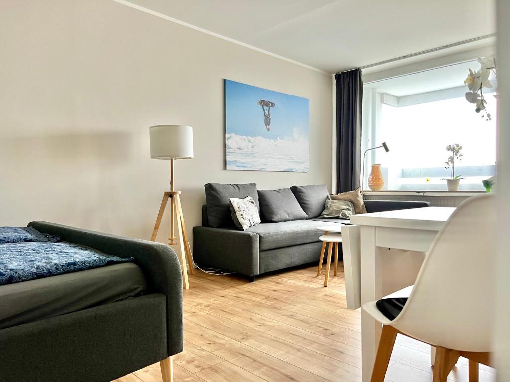 ein Wohnzimmer mit Sofa und Tisch in der Unterkunft WEITBLICK APARTMENT direkt am Park mit kostenlosem Parkplatz in Bremerhaven