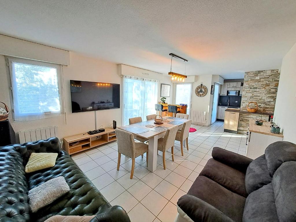 - un salon avec un canapé et une table à manger dans l'établissement Au calme, centre ville, draps, wifi, à Pornichet