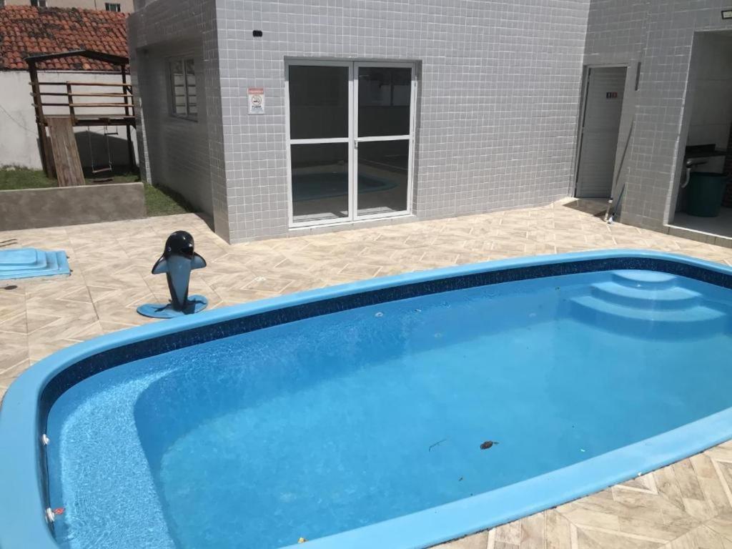 un giocattolo di Batman è seduto accanto a una piscina di Apartamento João Pessoa -apt completo 2 quartos casal a João Pessoa