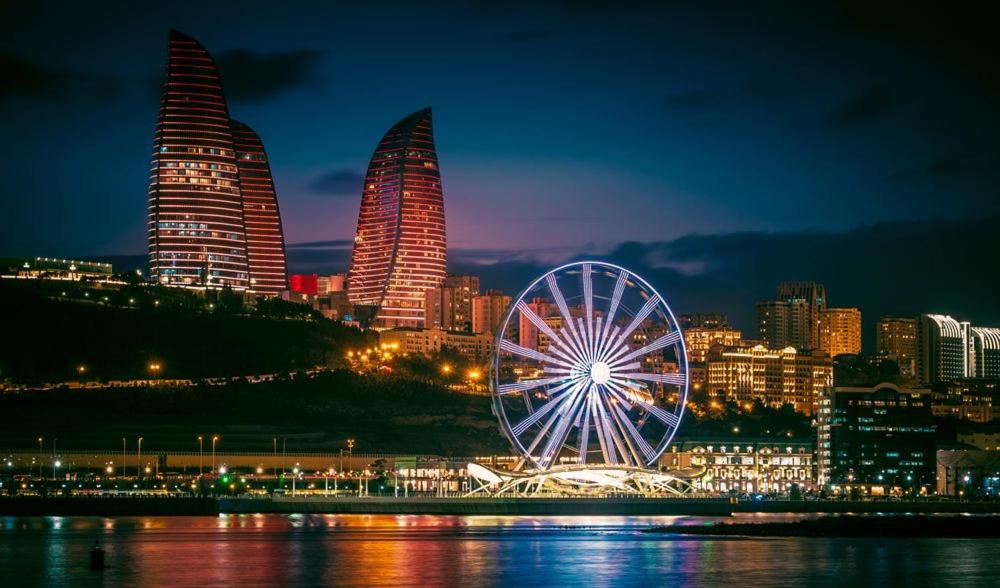 a ferris wheel in front of a city at night at HOSTEL124 in Baku