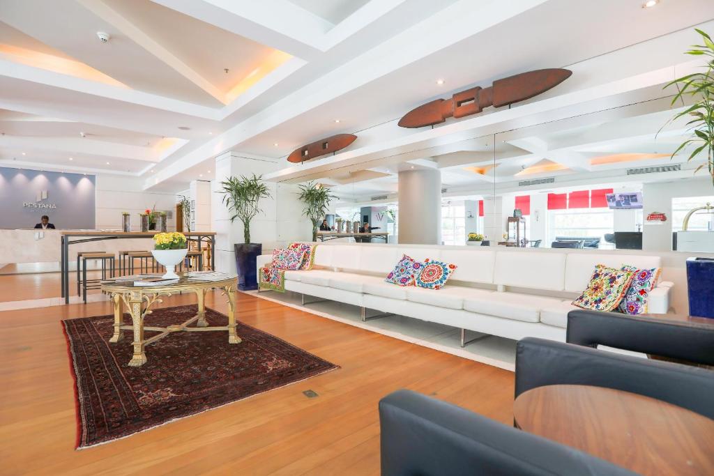 a living room with a white couch and a table at Pestana Curitiba in Curitiba