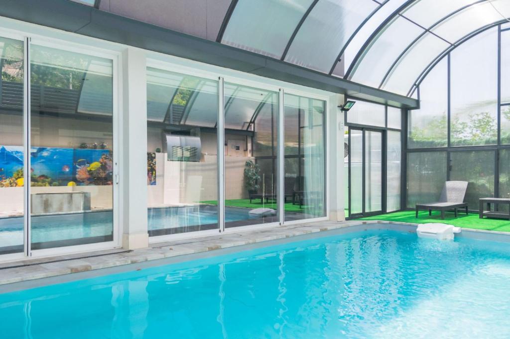 a house with a swimming pool with glass walls at VILLA 5 PLAYA A 2 MINUTOS in Castelldefels