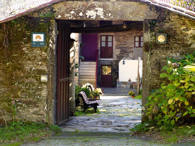 una entrada a una casa con un banco en la puerta en A Pena de Augasantas en Oca de Abaixo