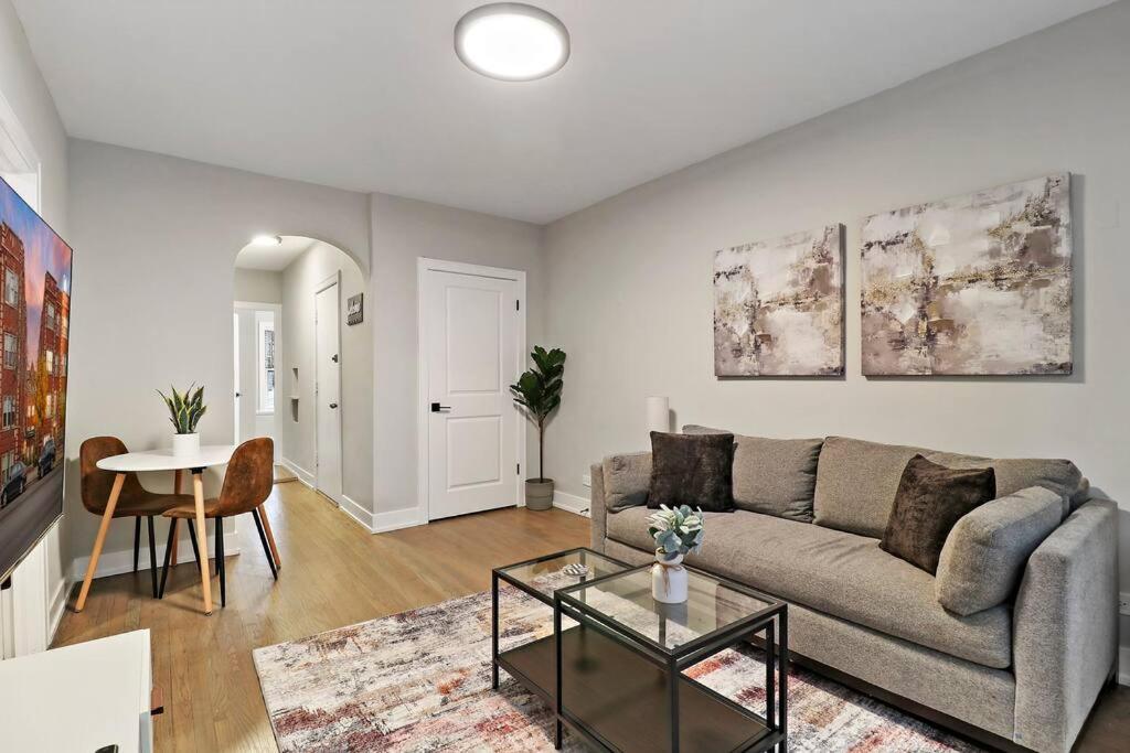 ein Wohnzimmer mit einem Sofa und einem Tisch in der Unterkunft Elegant 2BR Chicago Apartment - Montrose 1A in Chicago