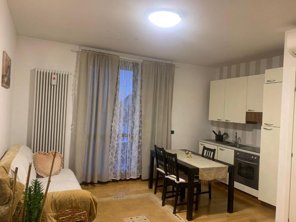 eine kleine Küche und ein Esszimmer mit einem Tisch und Stühlen in der Unterkunft Grazioso appartamento a Osteria Nuova in Sala Bolognese