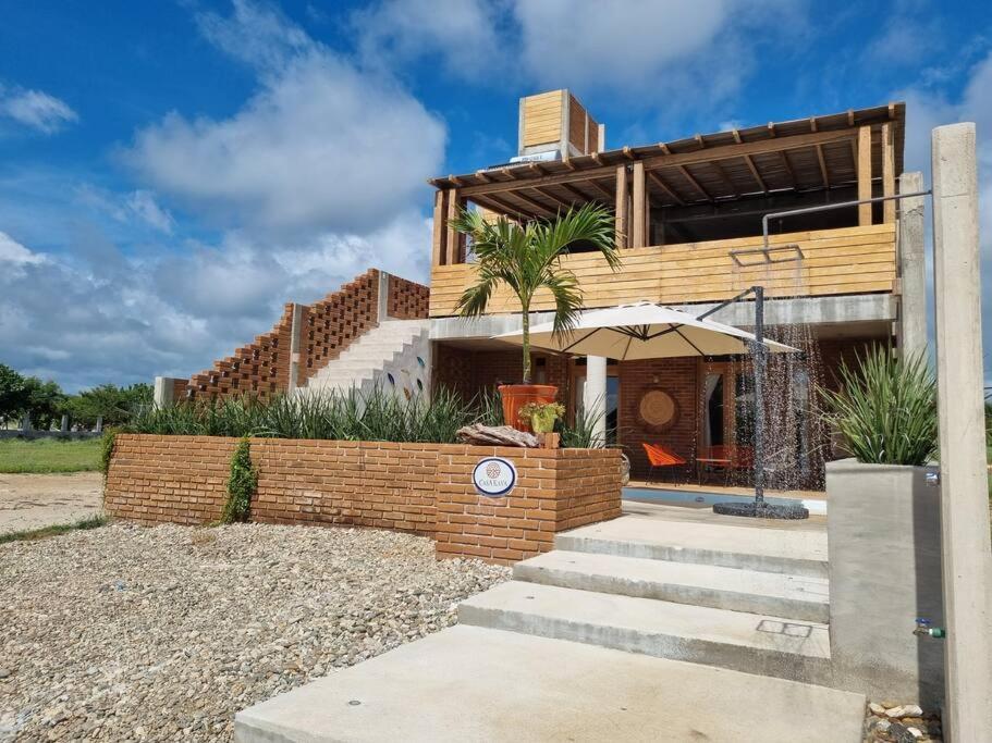 une maison avec des escaliers et un parasol en face de celle-ci dans l'établissement Espectacular villa Playa Tierra Blanca - 20 min Zicatela, à Tlachicón